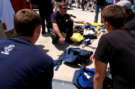 US Navy 070426-N-4163T-290 Chief Special Warfare Operator Larry E. Summerfield II, attached to the U.S. Navy Parachute Team, demonstrates proper parachute packing procedures to members of the Navy's Delayed Entry Program photo