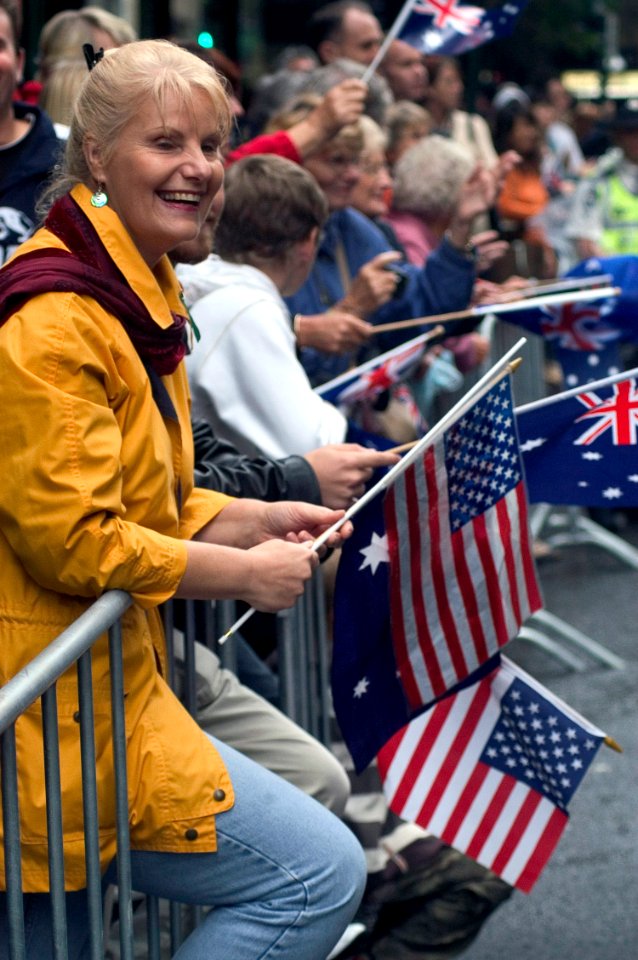 US Navy 070425-N-5253W-002 An Australian woman waves American and Australian flags as USS Lassen (DDG 82) Sailors march by during the Australia-New Zealand Army Corps (ANZAC) Day Parade