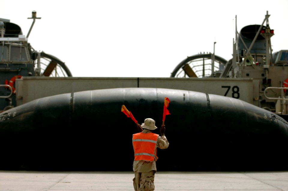 US Navy 070420-N-9818V-091 Seaman Dante Massey, attached to Beach Master Unit (BMU) 2, guides in a landing craft air cushion (LCAC) during an offload of troops and equipment attached to the 26th Marine Expeditionary Unit (MEU)