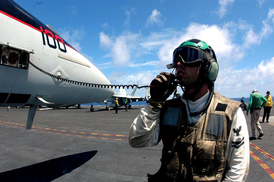 US Navy 070425-N-9760Z-017 Aviation Machinist's Mate 2nd Class James Cunningham, assigned to the Black Aces of Strike Fighter Squadron (VFA) 41, communicates with the pilot inside the aircraft