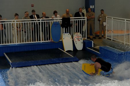 US Navy 070426-N-3642E-167 Secretary of the Navy (SECNAV), the Honorable Dr. Donald C. Winter watches Staff Sgt. William Corps boogie board on a wave machine at the Center for the Intrepid