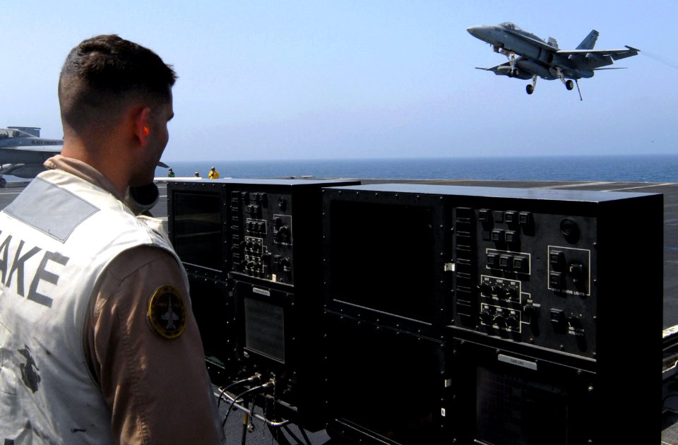 US Navy 070424-N-3038W-105 Capt. James Topping, from the Death Rattlers of Marine Strike Fighter Squadron (VMFA) 323, stands at the controls of the landing signal officer (LSO) platform