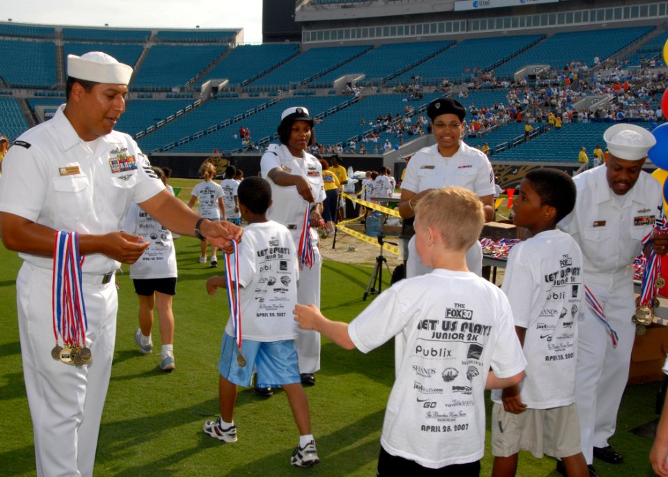 US Navy 070428-N-1522S-030 Naval Station Mayport Sailors pass out medals to children participating in the Let Us Play 2k Run at the Jacksonville Municipal Stadium