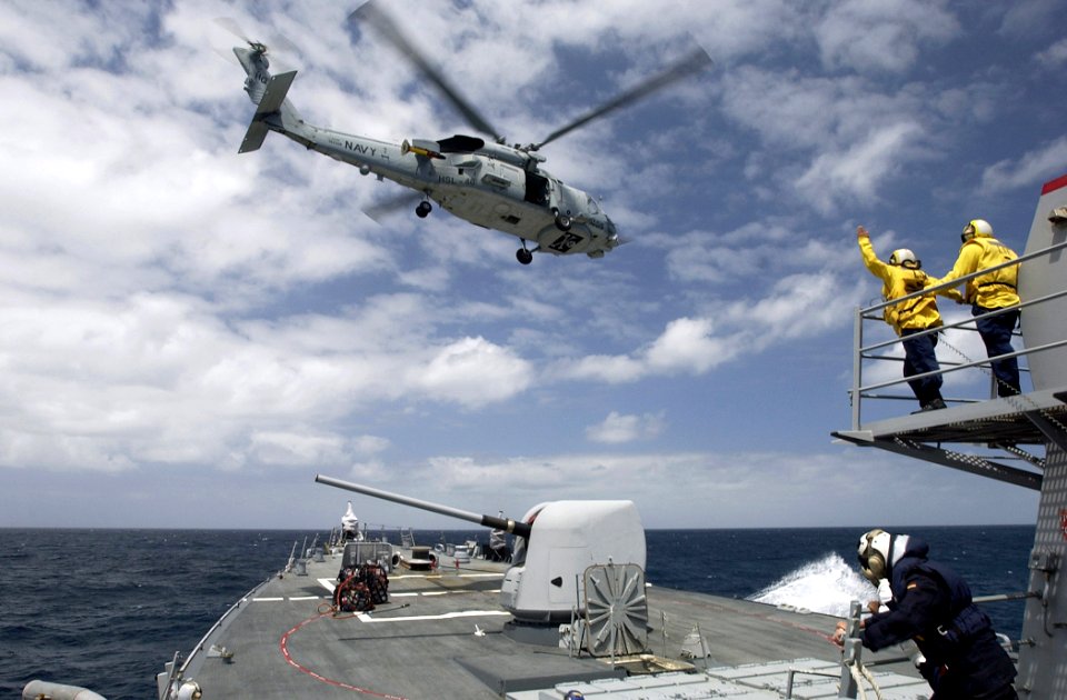 US Navy 070428-N-5459S-124 A Landing Signal Enlisted (LSE) directs a SH-60B helicopter, assigned to Helicopter Anti-Submarine Squadron Light (HSL) 46 Det. 6, as it delivers supplies on the forecastle of the guided-missile destr