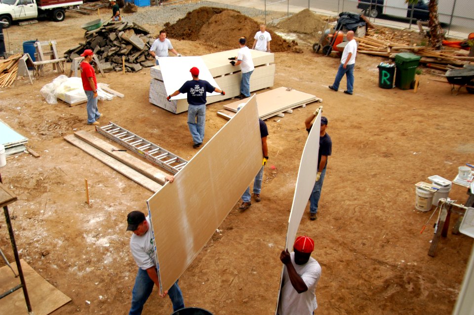 US Navy 070502-N-6410J-025 Sailors carry pieces of drywall into several homes. Sailors from Submarine Squadron 11 volunteered to help San Diego Habitat for Humanity