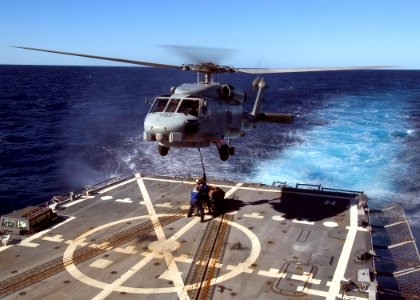 US Navy 070430-N-5253W-005 Sailors aboard the Arleigh burke-class guided-missile destroyer USS Lassen (DDG 82) connect a pallet to an SH-60B helicopter photo