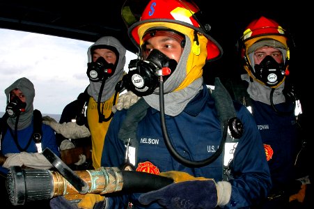 US Navy 070503-N-9760Z-001 Damage Controlman Fireman Aaron Nelson mans a two and one-half inch hose during a Class Bravo fire drill