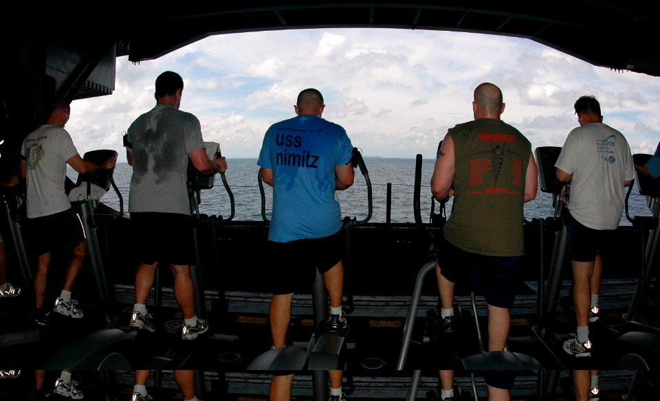 US Navy 070501-N-9760Z-014 Sailors work out while viewing passing islands in the hangar bay of the nuclear-powered aircraft carrier USS Nimitz (CVN 68)