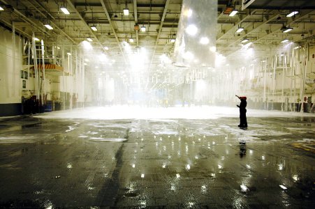 US Navy 070504-N-7883G-052 Engineering and air department Sailors observe tests of the aqueous film forming foam (AFFF) fire suppression system in hangar bay 1 on USS Kitty Hawk (CV 63)