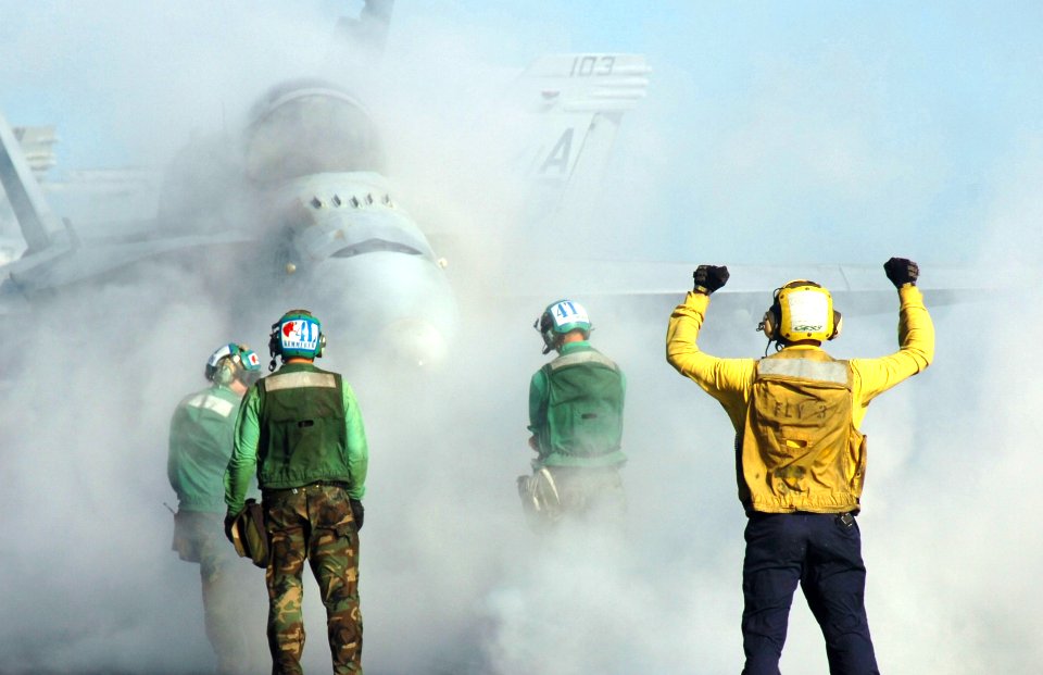 US Navy 070502-N-8907D-002 A plane director signals to the pilot of an F-A-18C Hornet from the Wildcats of Strike Fighter Squadron (VFA) 131 aboard Nimitz-class aircraft carrier USS Dwight D. Eisenhower (CVN 69)