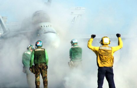 US Navy 070502-N-8907D-002 A plane director signals to the pilot of an F-A-18C Hornet from the Wildcats of Strike Fighter Squadron (VFA) 131 aboard Nimitz-class aircraft carrier USS Dwight D. Eisenhower (CVN 69)