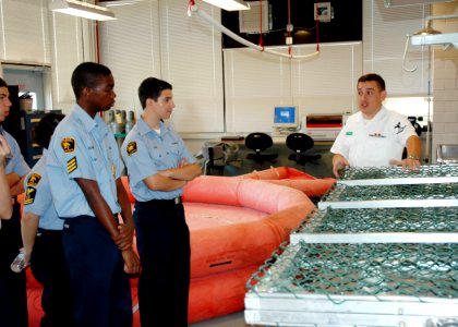 US Navy 070430-N-7427G-001 Aircrew Survival Equipmentman Shawn Parra demonstrates various life-saving gear during a visit by the Eisenhower Sea Cadet Unit from Avondale, La
