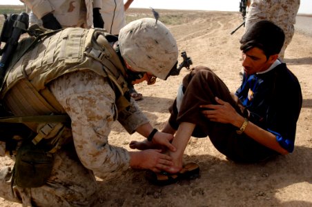 US Navy 070502-F-1062C-060 Hospital Corpsmen 3rd Class John McWaters aids an injured Iraqi during a patrol near the city of Jiyala