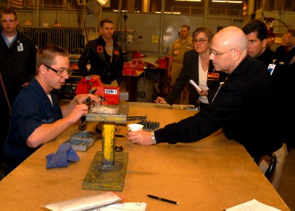 US Navy 070503-N-6247M-003 Aviation Structural Mechanic Airman Brian Palmquist, from Wenatchee, Wash., shows Rear Adm. Michael Hardee, commander Fleet Readiness Centers, the air baffles that are attached to the engine cowling o photo