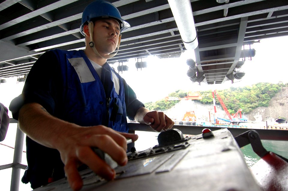 US Navy 070501-N-7883G-016 Boatswain's Mate Seaman Chanoc Domenech from Bronx, N.Y., operates a boat davit during a man overboard drill on USS Kitty Hawk (CV 63)