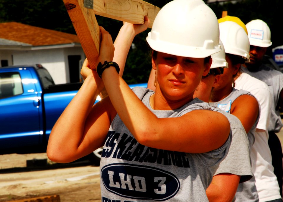 US Navy 070503-N-1831S-106 Information Systems Technician 2nd class Brittany Aubuchon helps carry a roofing frame during a community relations project