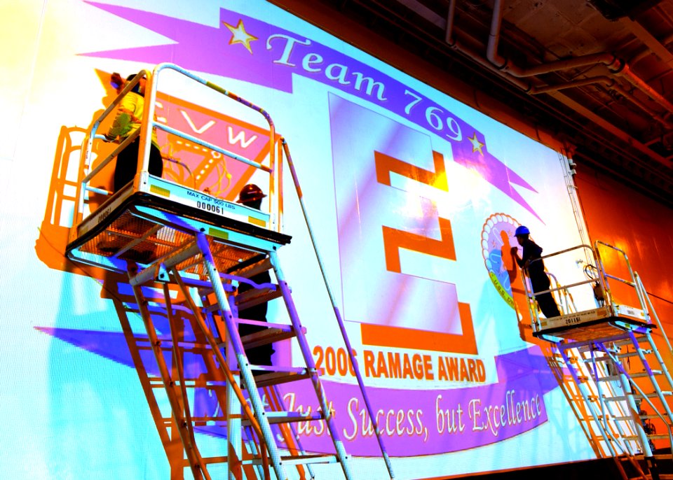 US Navy 070504-N-6854D-003 Sailors paint a Battle E and Ramage award emblem on the hangar bay doors of Nimitz-class aircraft carrier USS Dwight D. Eisenhower (CVN 69)