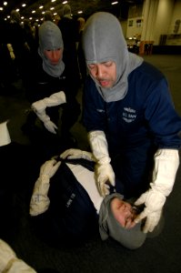 US Navy 070506-N-7883G-006 Hospital Corpsman 2nd Class John Obregonpaz from Brooklyn, N.Y., conducts cardio pulmonary resuscitation (CPR) training during a general quarters (GQ) drill in hangar bay one of USS Kitty Hawk (CV 63)