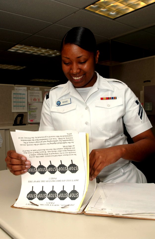 US Navy 070503-N-2143T-003 Personnel Specialist Seaman Apprentice Kimberly Mcghee verifies a Sailor's service record to ensure proper documentation is complete before filing records at the Naval Base Kitsap Personal Suppo