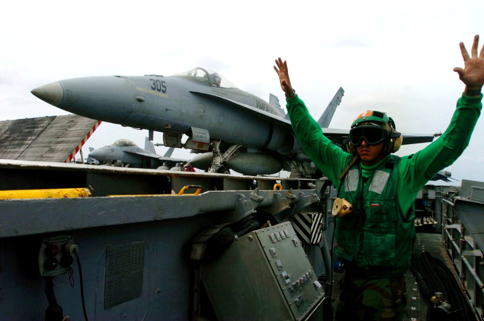 US Navy 070503-N-4420S-120 Aviation Boatswain's Mate Equipment 3rd Class Edwardo Villagomez signals hands off as an F-A-18A Hornet