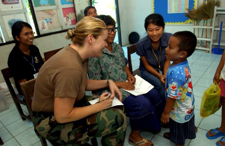 US Navy 070509-F-7806C-008 Hospital Corpsman 3rd Class Shauer, from Operational Support Hospital Unit (OSHU), talks to a local child during the distribution of prescription glasses in support of Cobra Gold 2007 photo