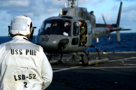 US Navy 070505-N-7029R-050 Boatswain's Mate 1st Class Everett Albright, flight safety operator, over looks flight deck operations while a Brazilian navy helicopter awaits take off from USS Pearl Harbor (LSD 52) during UNI photo