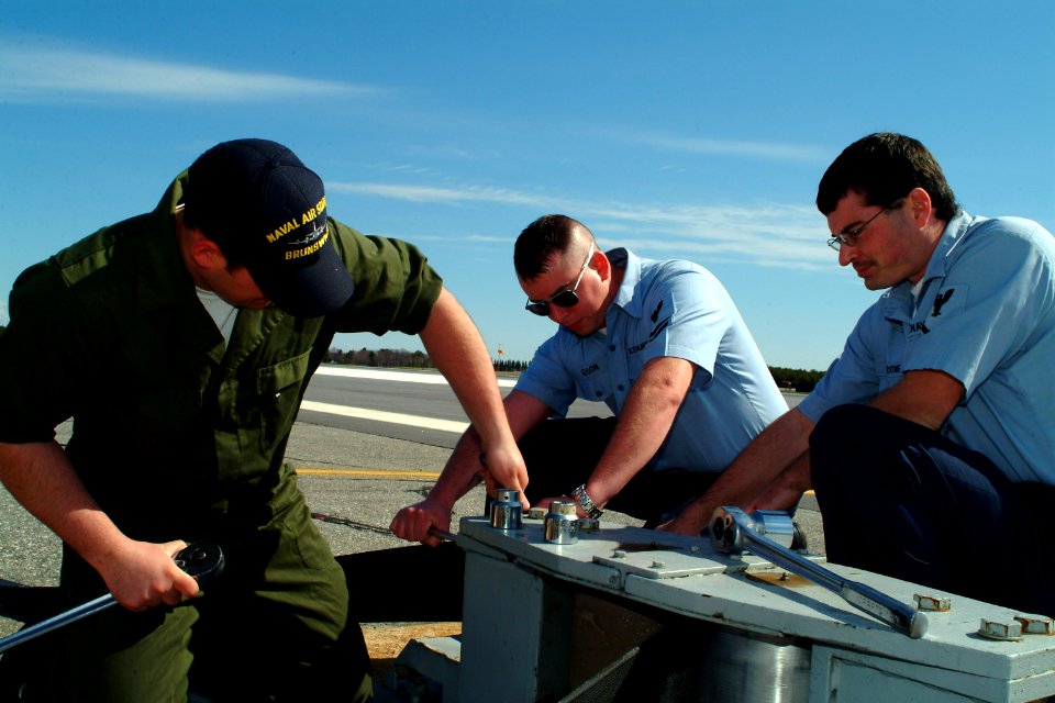 US Navy 070505-N-0411D-008 Naval Air Station Brunswick transient line maintenance technician Aviation Boatswain's Mate 2nd Class David Burgoon remove a sheave from an E-28's arresting gear as part of annual maintenance