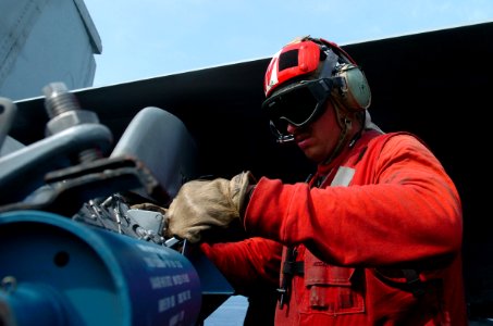 US Navy 070507-N-4420S-057 Aviation Ordnanceman 2nd Class Chris Preston, assigned to the Black Aces of Strike Fighter Squadron (VFA) 41, hooks up ordnance to an F-A-18F Super Hornet aboard nuclear-powered aircraft carrier USS N
