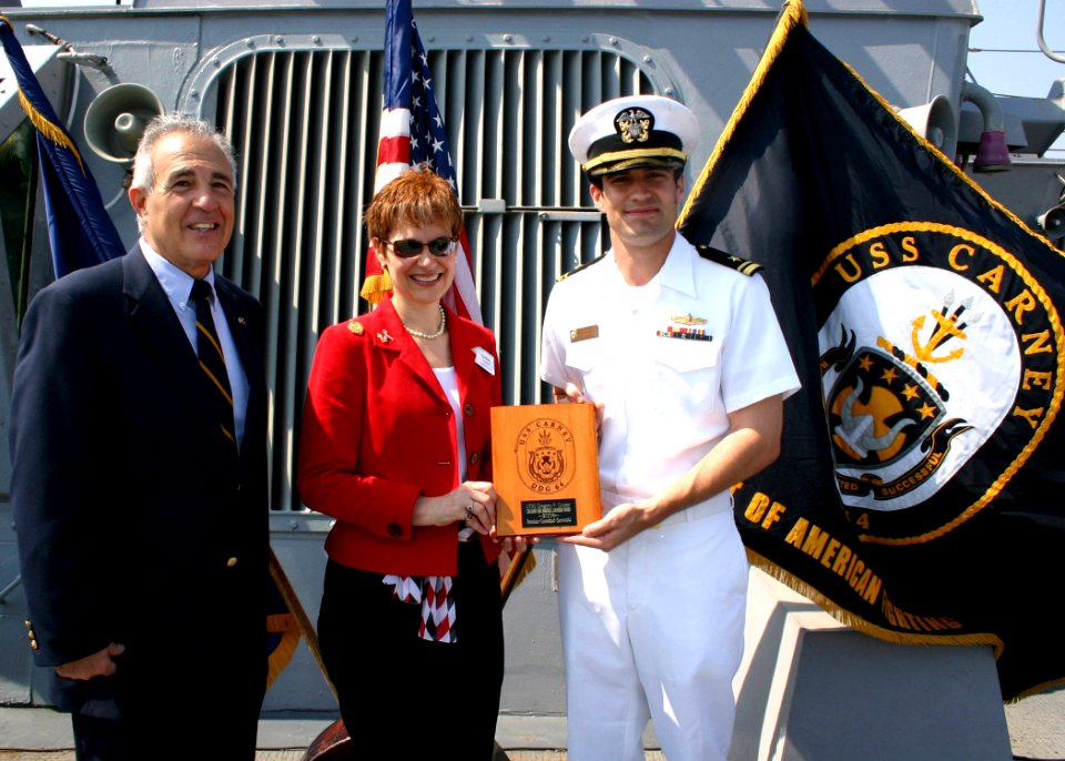 US Navy 070511-N-8544C-005 Mr. John Palombi, Naval Academy Class of 1964, and Mrs. Lanny King award Lt. j.g. Greg Cruser a plaque as the 2006 recipient of the Cmdr. Lanny King Memorial Leadership Award