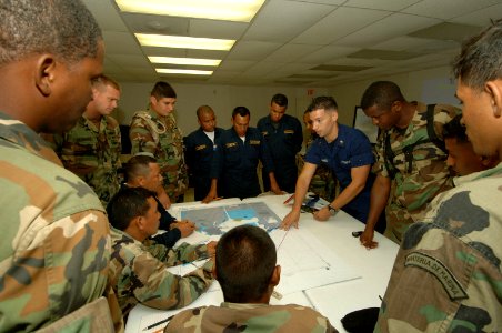 US Navy 070507-N-0989H-050 Boatswain's Mate 2nd Class Juan Rodriguez, Expeditionary Training Command, assists Panamanian National Maritime Service members with finding a point on a map given the latitude and longitude during tr