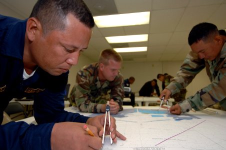 US Navy 070508-N-0989H-041 A Panamanian National Maritime Service (foreground) member plots a point on a chart
