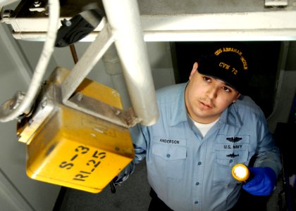 US Navy 070508-N-7981E-004 Culinary Specialist Seaman Ryan P. Anderson, of supply department's S-13 maintenance division, uses a telescoping mirror to check overhead fixtures for signs of corrosion