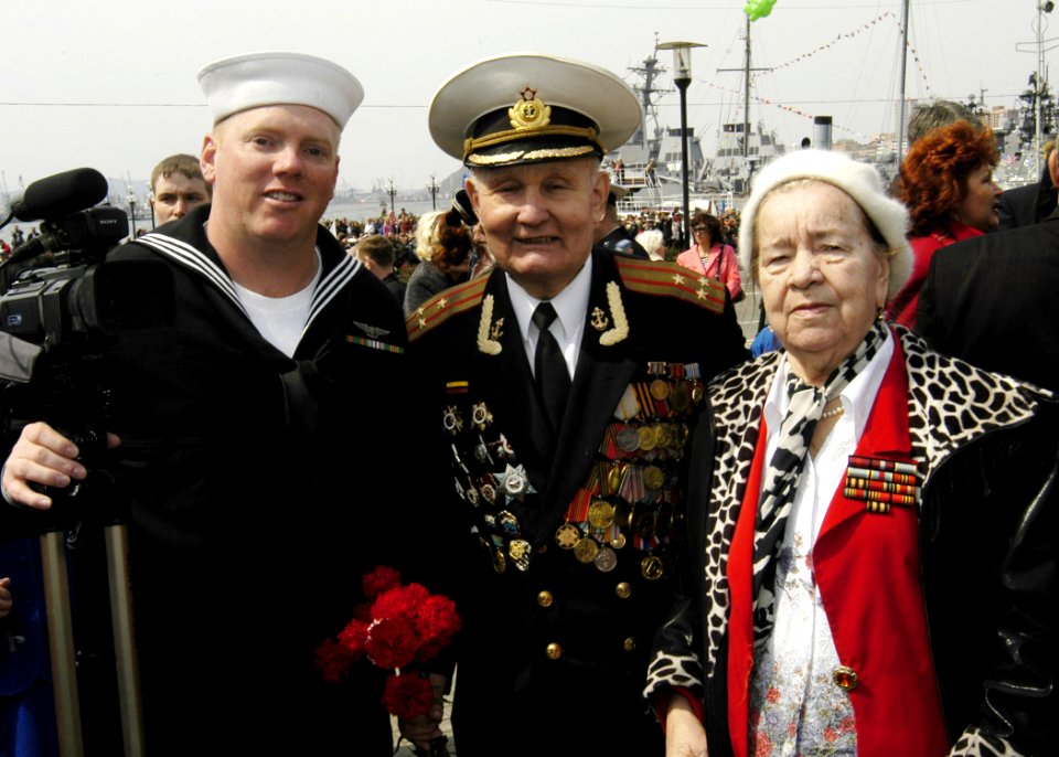 US Navy 070509-N-4649C-135 Mass Communication Specialist 2nd Class Robert Cole poses for a photograph with World War II veterans after filming a Victory Day celebration in Vladivostok