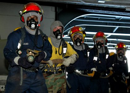 US Navy 070511-N-7128A-017 Sailors man a hose during a fire drill in the hangar bay aboard the nuclear-powered aircraft carrier USS Nimitz (CVN 68)