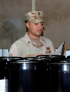 US Navy 070516-N-1003P-001 Hospital Corpsman 2nd Class Abran Gonzalez, preventive medicine technician, looks at food containers inside the Bob Hope Dining Facility