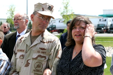 US Navy 070508-N-0975R-002 The wife of Electrician's Mate 1st Class Charles Komppa watches on the arm of Utilitiesman 1st Class J Williamson as the Charles V. Komppa wing is revealed for the first time