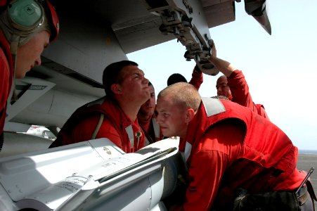 US Navy 070511-N-0890S-015 Aviation Ordnancemen assigned to the Tophatters of Strike Fighter Squadron (VFA) 14 load a 500 pound MK-82-BLU 111 general-purpose bomb onto a F-A-18E Super Hornet