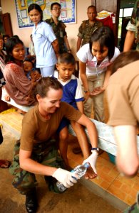 US Navy 070517-F-7806C-007 Hospital Corpsman 2nd Class Ledbetter from Occupational Hospital Support Unit (OHSU), treats a Thai boy with foot injuries in Ban Nong Pawa School during Cobra Gold 2007