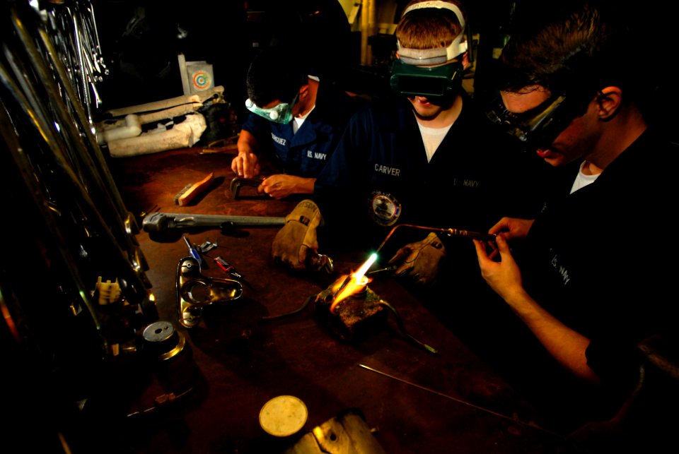 US Navy 070514-N-2659P-144 Hull Technician Fireman Noah Rodriguez, left, performs tool maintenance while Hull Technician Fireman Zach Carver, center, assists Hull Technician Fireman Keir Burnette with brazing