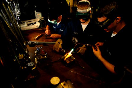 US Navy 070514-N-2659P-144 Hull Technician Fireman Noah Rodriguez, left, performs tool maintenance while Hull Technician Fireman Zach Carver, center, assists Hull Technician Fireman Keir Burnette with brazing