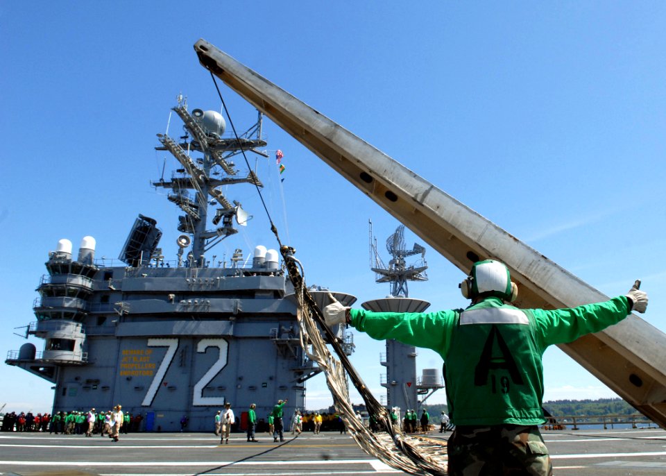 US Navy 070508-N-7981E-111 A member of air department's V-2 division signals to stand clear as flight deck personnel raise an emergency barricade on the flight deck of Nimitz-class aircraft carrier USS Abraham Lincoln (CVN 72)