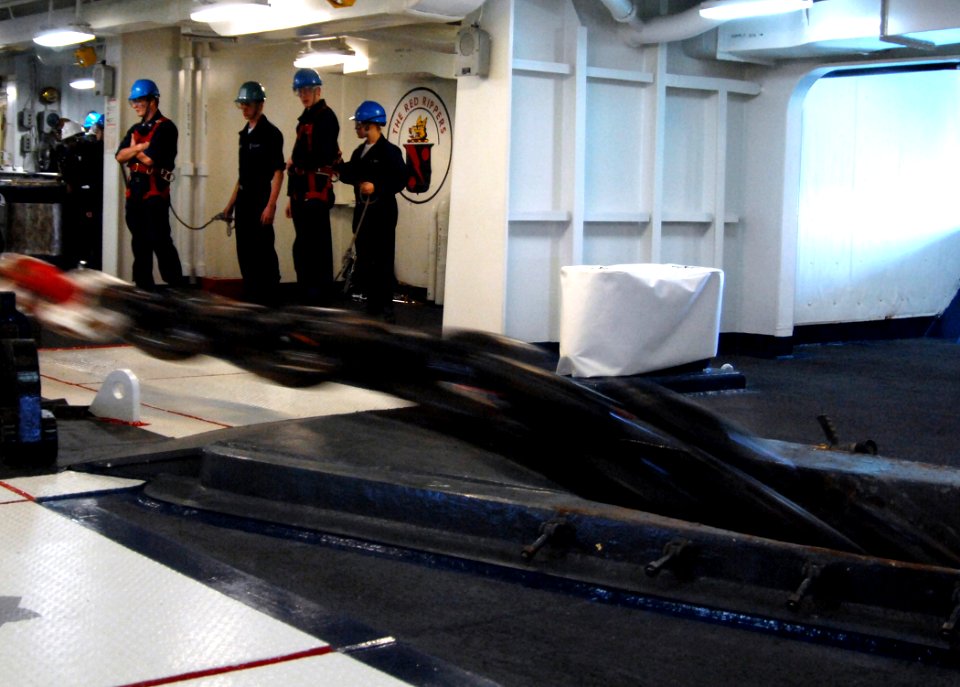 US Navy 070514-N-8923M-068 Sailors from deck department keep their distance as an anchor chain is released into the ocean during a precision anchoring exercise in the forecastle aboard Nimitz-class aircraft carrier USS Harry S