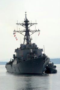 US Navy 070515-N-3390M-001 Guided missile destroyer USS Benfold (DDG 65) is assisted by a tug boat she prepares to moor pier side at Naval Station Everett for a port visit