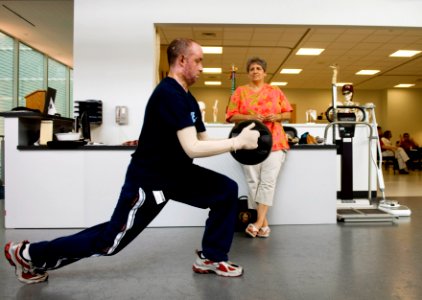 US Navy 070509-N-5319A-010 Chief Engineman Peter Johns performs rehab exercises while his mother watches in the Center for the Intrepid aboard Brooke Army Medical Center (BAMC)