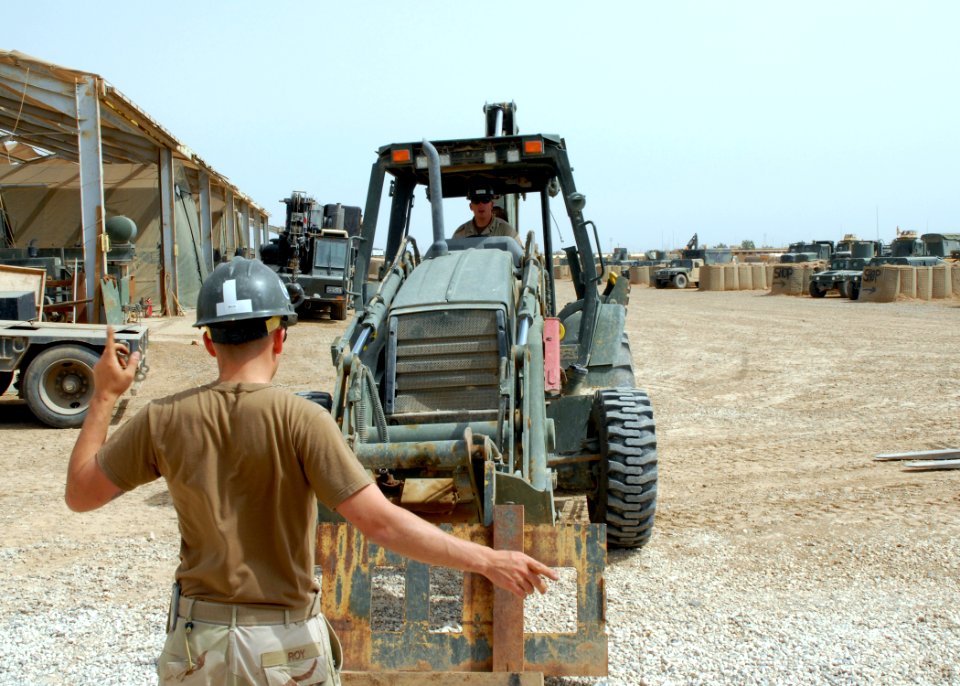 US Navy 070515-N-3560G-051 Equipment Operator 3rd Class Mathew Roy of Naval Mobile Construction Battalion (NMCB) 4 directs Equipment Operator 1st Class Joie McCarty during forklift operations