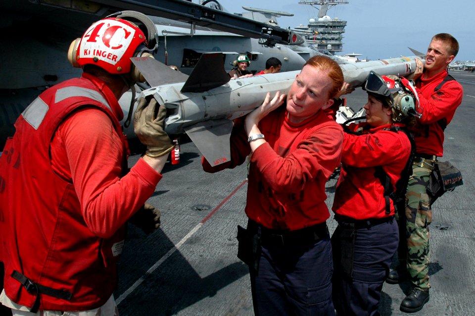 US Navy 070511-N-0890S-029 Aviation Ordnancemen assigned to the Sunliners of Strike Fighter Squadron (VFA) 81 load a AIM-9X Sidewinder missile onto an F-A-18C Hornet