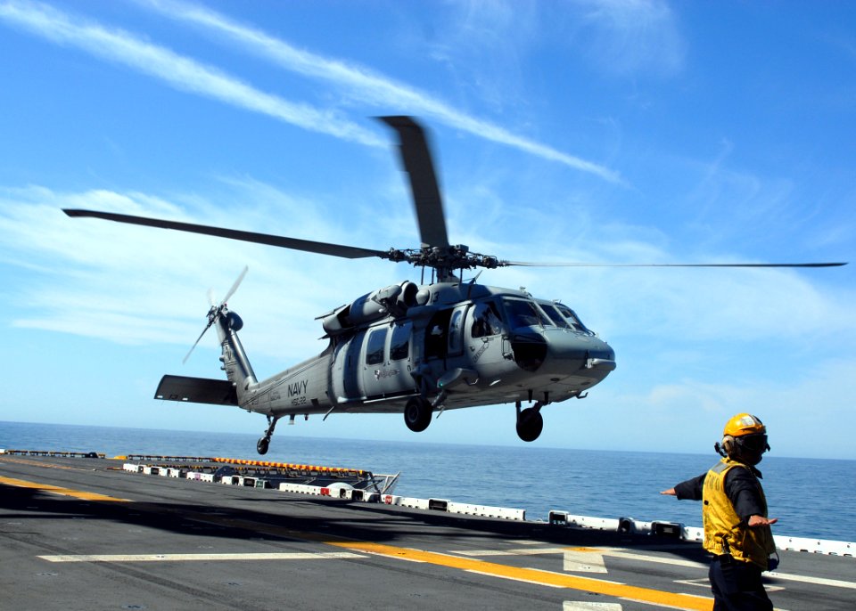US Navy 070514-N-5033P-194 A Sailor guides a MH-60S Seahawk assigned to Helicopter Sea Combat (HSC) 22 onto the flight deck aboard the amphibious assault ship USS Kearsarge (LHD 3)