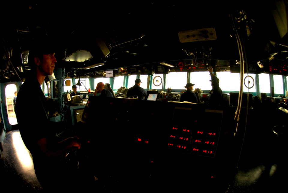 US Navy 070518-N-0684R-026 Seaman John Moen mans the helm during low visibility conditions caused by a sandstorm at sea aboard Arleigh Burke-class guided-missile destroyer USS Preble (DDG 88)