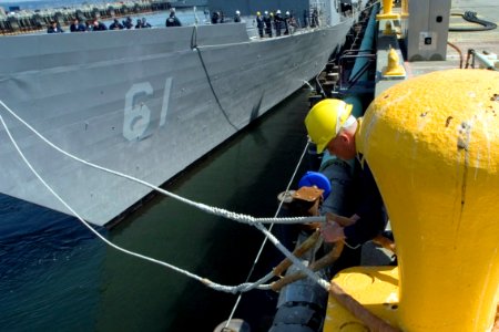 US Navy 070518-N-3390M-005 Boatswain's Mate 2nd Class Randal Walters, assigned to guided-missile destroyer USS Shoup (DDG 86), dips the eye while securing forward mooring lines to a bollard as guided-missile frigate USS I