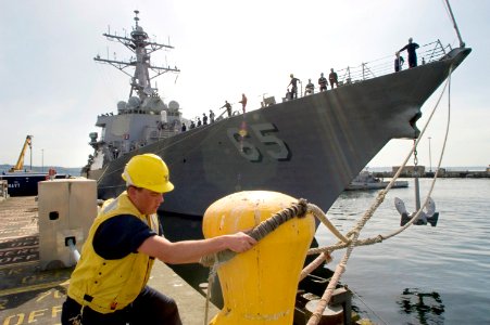US Navy 070515-N-3390M-003 Boatswain's Mate 2nd Class Randal Walters assigned to guided missile destroyer USS Shoup (DDG 86) secures the forward mooring lines to a bollard as guided missile destroyer USS Benfold (DDG 65)